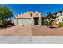 Tan two-story house with a two-car garage and landscaped yard at 17986 W Fulton St, Goodyear, AZ 85338