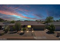 Brick ranch home with a two-car garage and mature landscaping at 4117 E Carol Ave, Mesa, AZ 85206