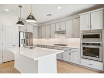 Modern kitchen with white cabinets, stainless steel appliances, and kitchen island at 6412 N 17Th Pl, Phoenix, AZ 85016