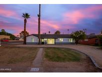 Newly renovated home with landscaping and a beautiful sunset at 1147 E Flynn Ln, Phoenix, AZ 85014