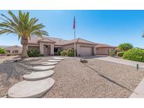 One-story home with Spanish tile roof, flag, and desert landscaping at 12909 W Meeker Blvd, Sun City West, AZ 85375