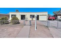Single story home with a garage and gated walkway at 3002 W Latham St, Phoenix, AZ 85009