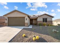 One-story home with a brown garage door and desert landscaping at 1940 W Ringo Rd, Wickenburg, AZ 85390