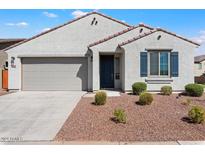 Front view of a single-story house with a two-car garage and landscaping at 15112 W Hadley St, Goodyear, AZ 85338