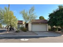 Tan colored stucco home with a white garage door and mature landscaping at 7006 E Jensen St # 83, Mesa, AZ 85207