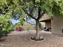 Landscaped backyard with patio and mature trees at 148 S 225Th Ln, Buckeye, AZ 85326