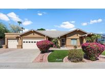 Beautiful tan home with a two-car garage and lush landscaping at 8894 E Sheena Dr, Scottsdale, AZ 85260