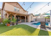 Large backyard with covered patio, pool, and string lights at 15402 W Old Oak Ln, Surprise, AZ 85379