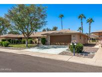 Single-story home with a two-car garage and landscaped yard at 12620 W Parkwood Dr, Sun City West, AZ 85375