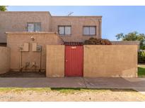 Tan stucco two-story building with a red gate at 6730 W Monterosa St, Phoenix, AZ 85033