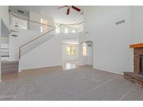 Two-story living room with staircase and views to other rooms at 40752 W Robbins Dr, Maricopa, AZ 85138