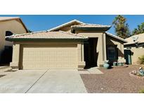 Single story house with tan exterior and two car garage at 5984 W Geronimo Ct, Chandler, AZ 85226