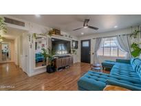 Living room with teal sectional sofa, large TV, and wood floors at 2047 W Maryland Ave, Phoenix, AZ 85015