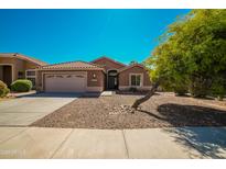 One-story home with a tan exterior and gravel landscaping at 7469 W Monona Dr, Glendale, AZ 85308