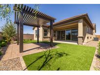 Backyard with pergola, grass, and sliding glass door access at 22427 E Oriole Way, Queen Creek, AZ 85142