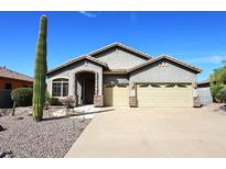 Single-story home with gray exterior, two-car garage, and desert landscaping at 5060 S Las Mananitas Trl, Gold Canyon, AZ 85118