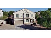 Two-story house with tan exterior and three-car garage at 15682 W Jenan Dr, Surprise, AZ 85379