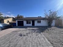 Newly renovated home with gray driveway and landscaping at 3143 W Glendale Ave, Phoenix, AZ 85051