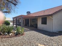 Back patio with pergola, providing shade and seating area at 18424 N 137Th Dr, Sun City West, AZ 85375