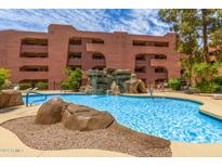 Inviting community pool with a rock waterfall feature at 12222 N Paradise Village Pkwy # 142, Phoenix, AZ 85032