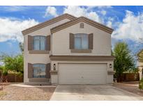 Two story home with beige exterior, brown shutters, and a two car garage at 42999 W Samuel Dr, Maricopa, AZ 85138