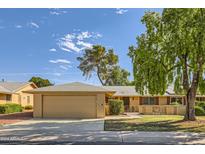 Tan house exterior with a two car garage and landscaping at 13605 N Redwood Dr, Sun City, AZ 85351