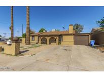 Single story home with a two-car garage and desert landscaping at 5850 W Cheery Lynn Rd, Phoenix, AZ 85031