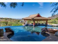 Infinity pool with a built-in bar and stunning panoramic mountain views at 15972 N 115Th Way, Scottsdale, AZ 85255