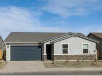 Single-story home with a two-car garage and stone accents at 8634 W Albeniz Pl, Tolleson, AZ 85353