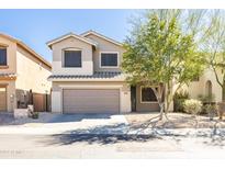 Two story house with attached garage and neutral color scheme at 40043 N High Noon Way, Anthem, AZ 85086