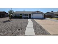 Single story home with gray exterior, attached garage, and rock landscaping at 8833 W Monroe St, Peoria, AZ 85345