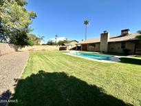 Refreshing backyard pool with expansive lawn at 4442 E Aire Libre Ave, Phoenix, AZ 85032