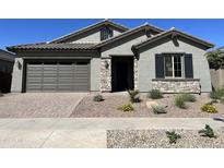 One-story home with gray siding, stone accents, and landscaping at 15922 W Electra Ln, Surprise, AZ 85379