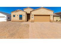 Tan stucco home with a two-car garage and landscaped yard at 9290 W Troy Dr, Arizona City, AZ 85123