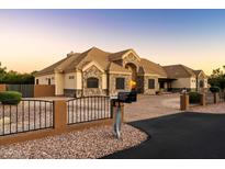 Large stone house with a long driveway and gate at 3317 E Mcdowell Rd, Mesa, AZ 85213