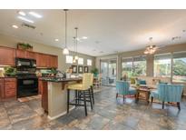 Kitchen boasts a large island, dark wood cabinets, and tile flooring at 12702 W Jasmine Trl, Peoria, AZ 85383