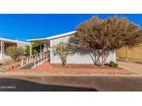 Mobile home with ramp access, mature trees, and a paved driveway at 2650 W Union Hills Dr # 54, Phoenix, AZ 85027