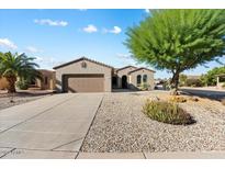 Single-story home with a two-car garage and nicely landscaped front yard at 16419 W Chuparosa Ln, Surprise, AZ 85387