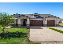 Two-story house with a three-car garage and a landscaped lawn at 7210 S 255Th Ave, Buckeye, AZ 85326