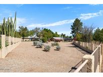 Large backyard with gravel, desert landscaping, and a tall metal fence at 4774 E Kiva St, Phoenix, AZ 85044