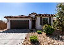 Charming house exterior with brown garage door and landscaping at 18767 W Canterbury Dr, Surprise, AZ 85388