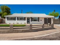 Newly remodeled mid-century modern home with a gray fence and landscaping at 7508 E Beatrice St, Scottsdale, AZ 85257