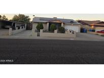 House exterior with driveway, garage, and solar panels at 4330 W Mescal St, Glendale, AZ 85304