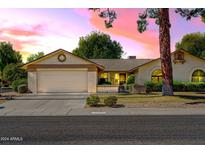 Single story home with a two-car garage and front yard at 12903 W Blue Sky Dr, Sun City West, AZ 85375
