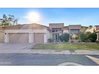 Modern home with a neutral color scheme, two car garage, and well-manicured lawn at 12028 N 80Th Pl, Scottsdale, AZ 85260