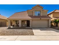 Two-story house with tan exterior, terracotta roof, and a two-car garage at 1229 E Windsong Dr, Phoenix, AZ 85048