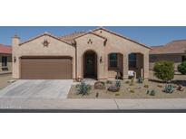 Tan two-car garage home with desert landscaping at 26404 W Zachary Dr, Buckeye, AZ 85396