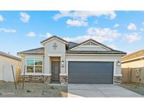 Single-story home with gray exterior, stone accents, and a two-car garage at 24125 W Flores Dr, Buckeye, AZ 85326