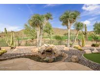 Serene backyard with a water feature, desert landscaping, and mountain views at 2412 W Hazelhurst Ct, Anthem, AZ 85086