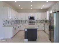 Modern kitchen with white cabinets, granite counters, and an island at 20358 N Valencia N Dr, Maricopa, AZ 85138